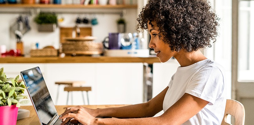 Woman at a table looking at a computer