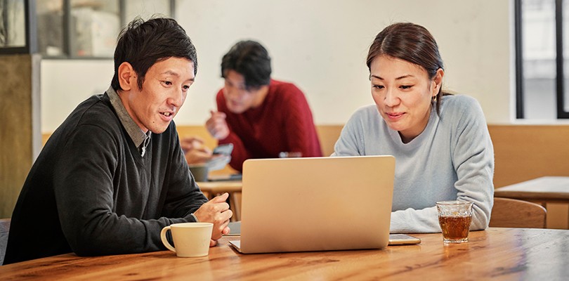 Man and woman holding a meeting in front of a laptop at a table