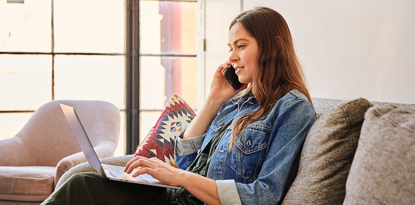 Woman working alone at laptop on her phone