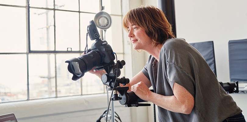 Videographer looking through the lens of a camera