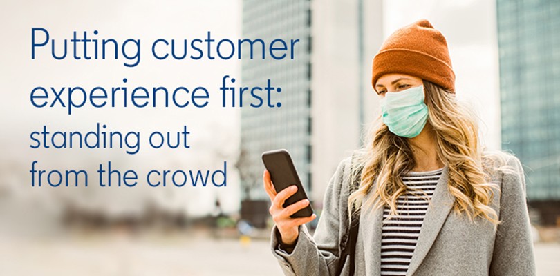 woman wearing a medical mask looking at a phone