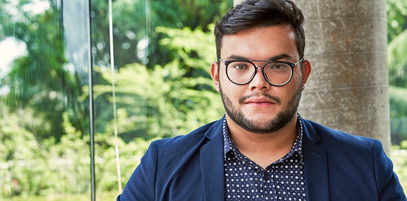 A portrait of a man wearing glasses and a blue blazer looking directly into the camera.