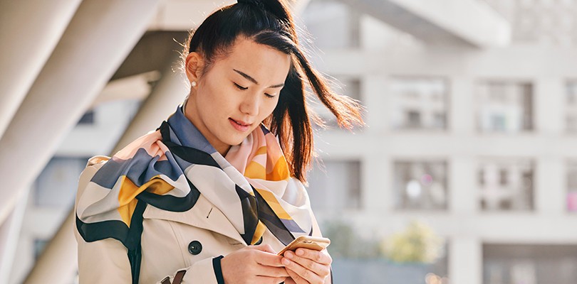Woman looking at phone outside