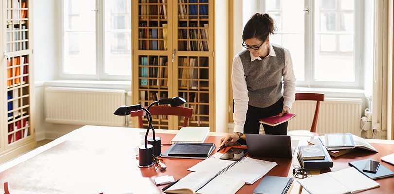 Female adult learner working alone in a library