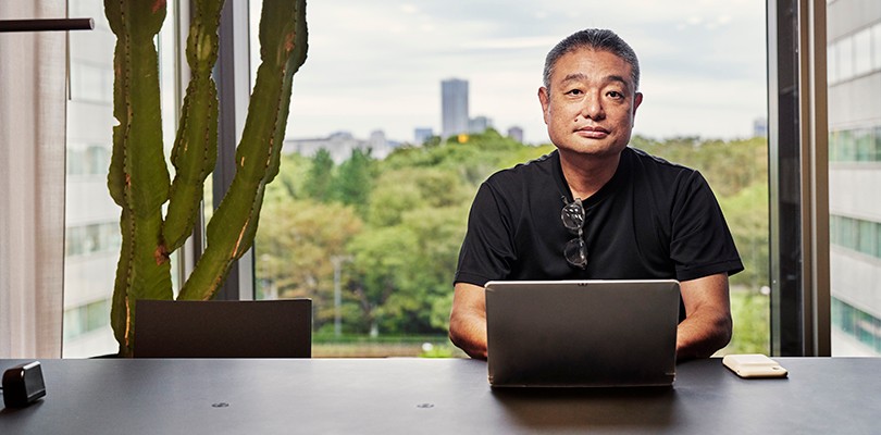 Man sitting at desk looking up behind a computer