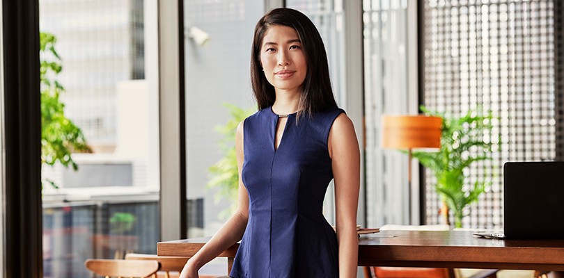 Portrait of a woman standing in an office looking directly in to the camera.