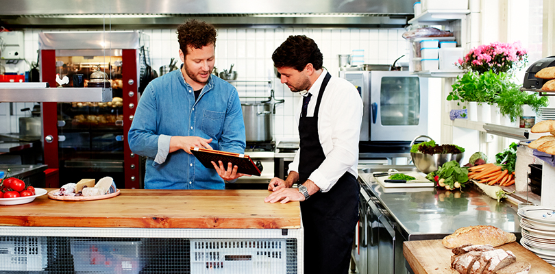 man using computer in kitchen