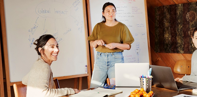 Group of women collaborating in a meeting room in front a dry erase boardGroup of women collaborating in a meeting room in front a dry erase board.