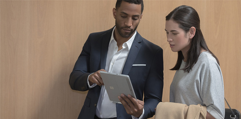 man shows woman something on his tablet