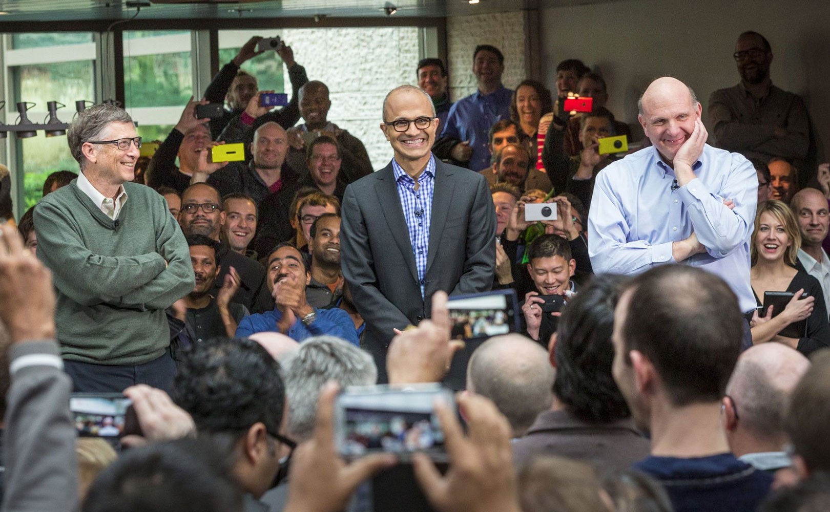 Photo of Microsoft employees gathered around Bill Gates and CEO Satya Nadella at employee rally