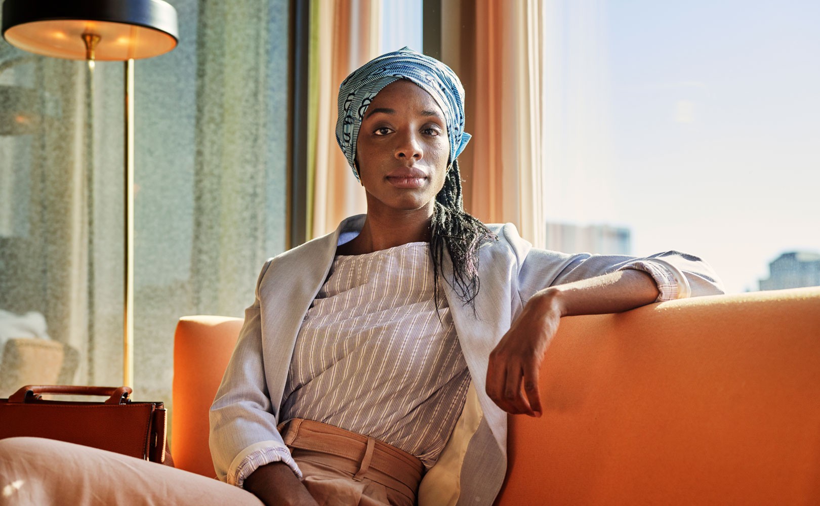 Photo of woman sitting on couch and looking at camera