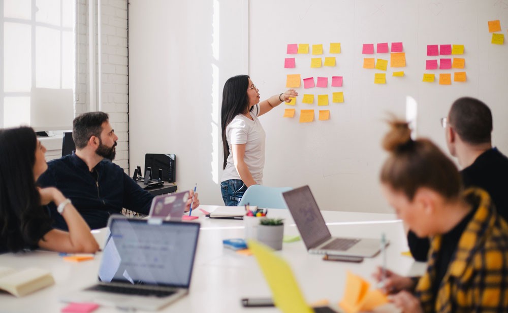 Photo of group of employees brainstorming with sticky notes