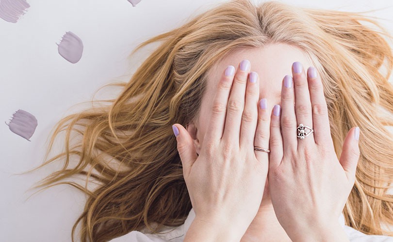 Photo of woman with her hands covering her eyes