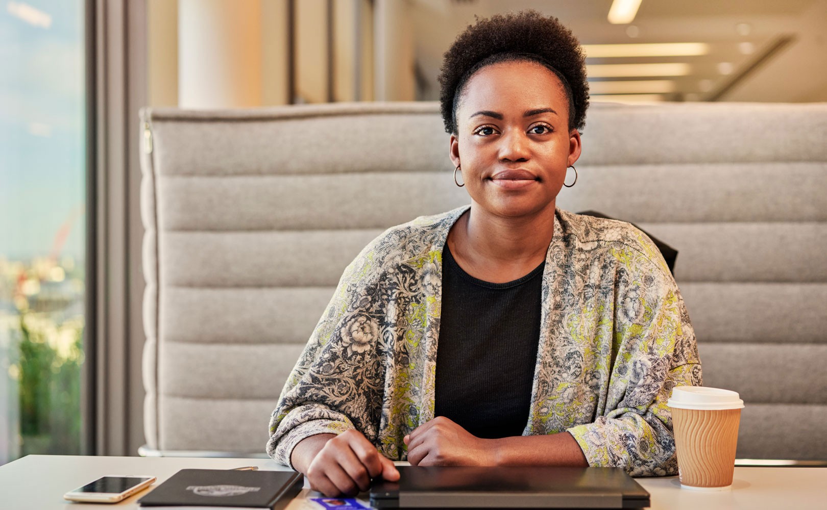 Photo of woman sitting at table and looking into camera