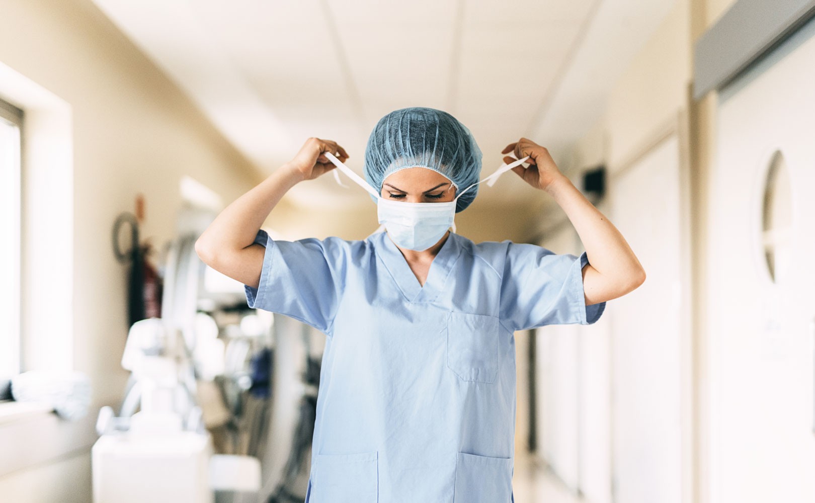 Photograph of nurse putting on face mask