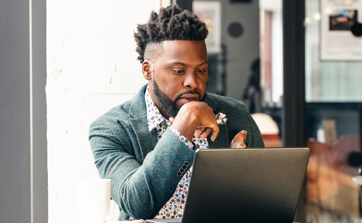Photo of man working on a laptop