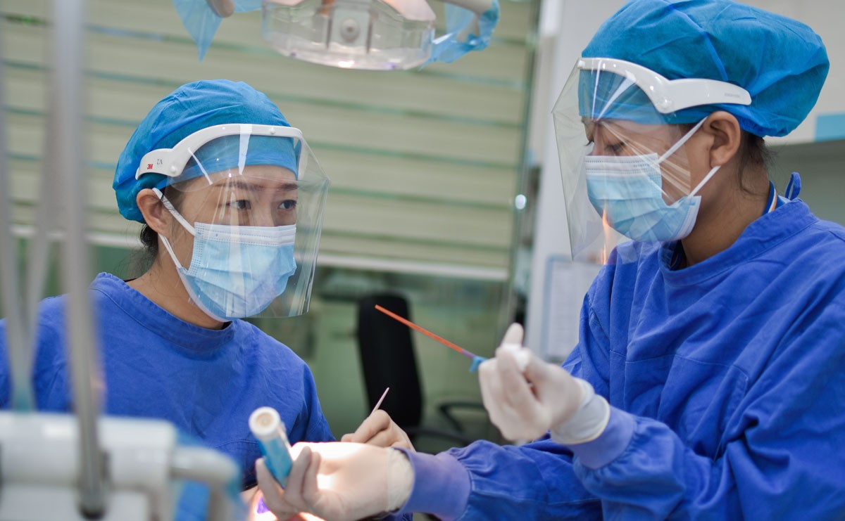 Photo of two healthcare workers wearing blue scrubs