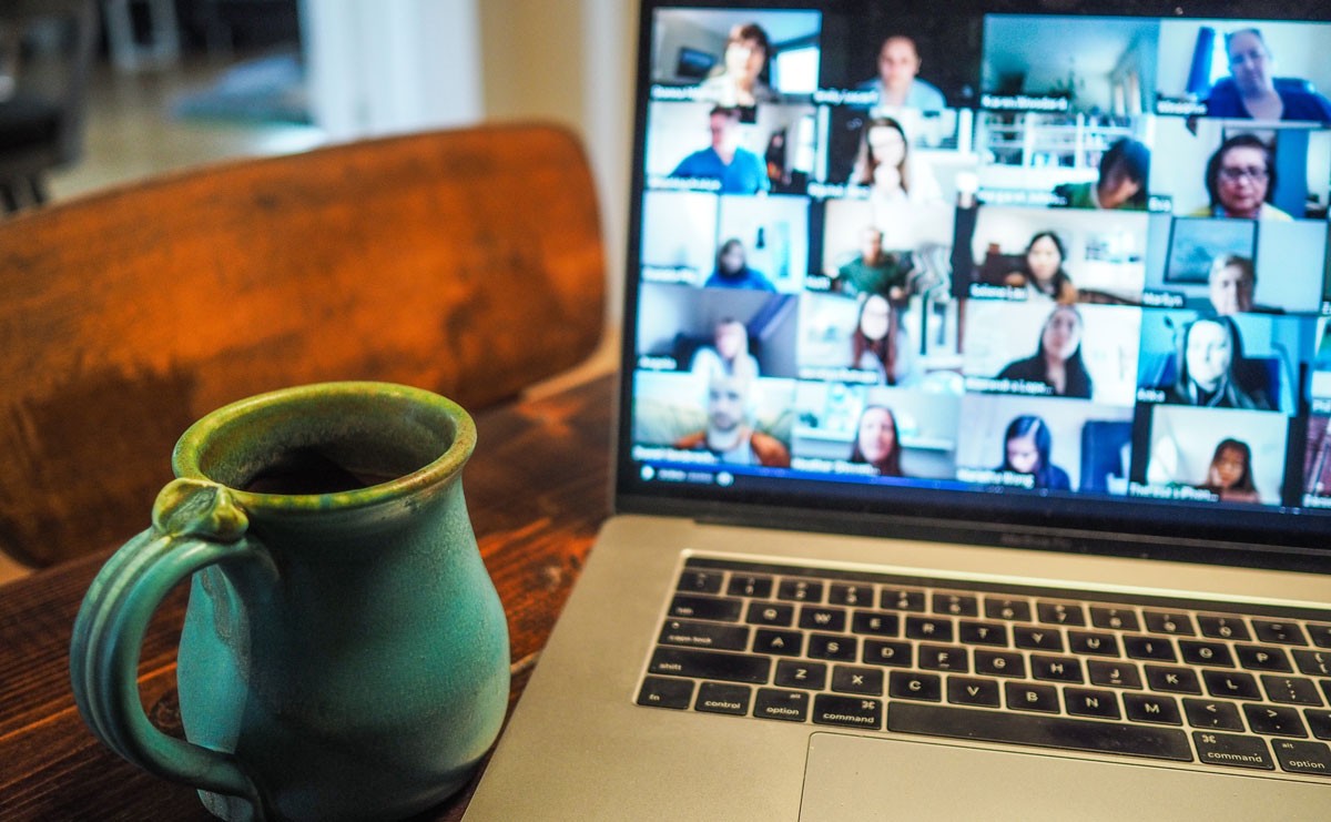 Photo of laptop and coffee cup during a video conferencing meeting