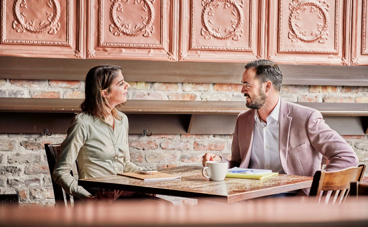 Photo of man and woman sitting at a table during an interview