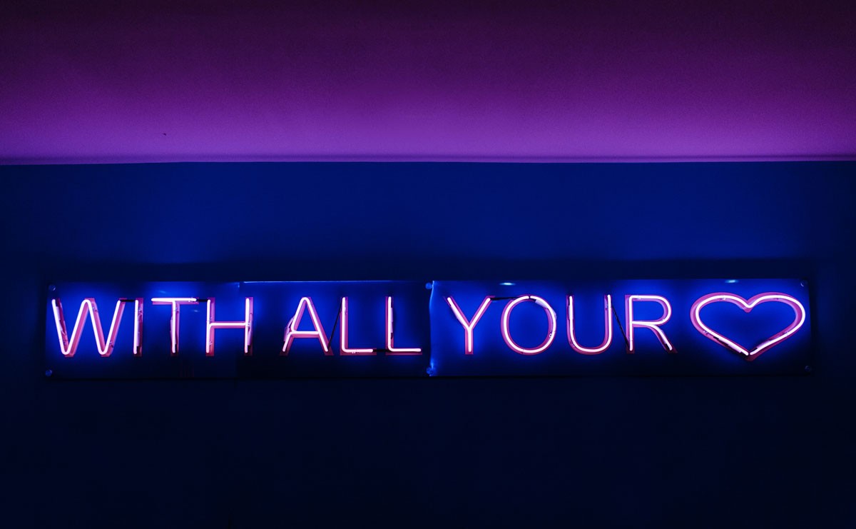 Photo of neon light that reads: With All Your Heart