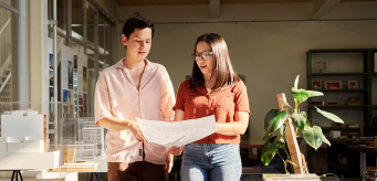 Two people discussing a plan on paper