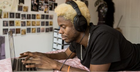 Image of man on laptop with headphones on