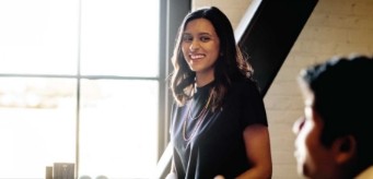 Une personne debout souriante.