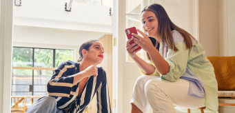 Two individuals sitting down together inside.