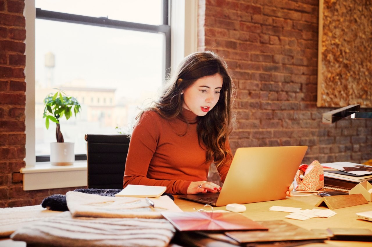 woman sitting at desk looking at a laptop