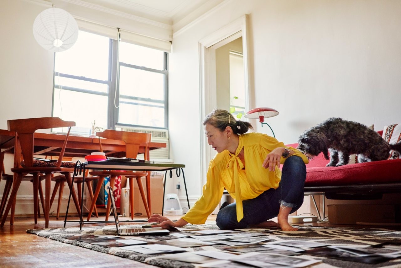 woman sitting in living room on rug looking at laptop